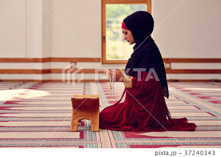 Young muslim woman praying in mosque 37240343