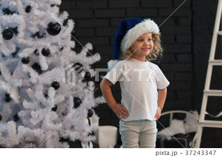 Cute little girl in a white T-shirt is standing 37243347