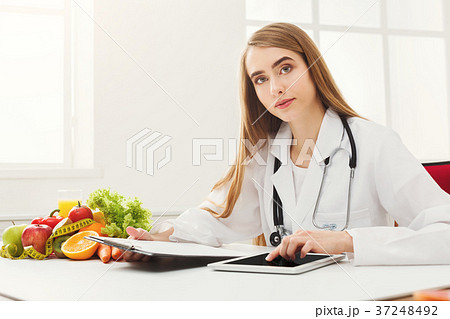 Female nutritionist working on digital tablet Female nutritionist working on digital tablet 37248492