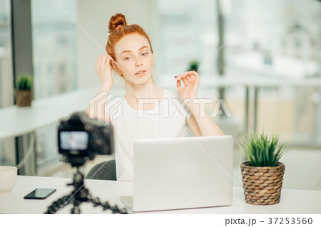 young woman broadcasting a hair tutorial for her 37253560