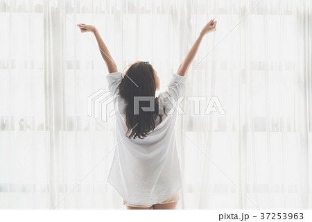 Asian girl stretching near a window Asian girl stretching near a window 37253963
