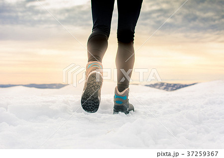 Person hiking on the mountaintop covered with snow 37259367
