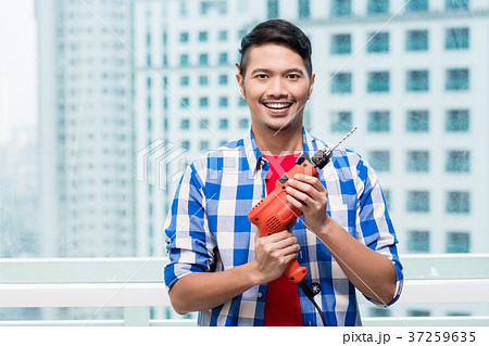 Young indonesian man with power drill 37259635
