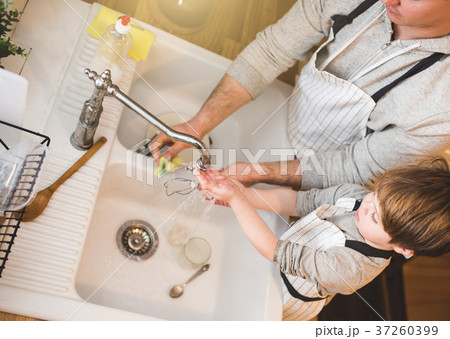 Dad and son doing the washing up in kitchen Dad and son doing the washing up in kitchen 37260399