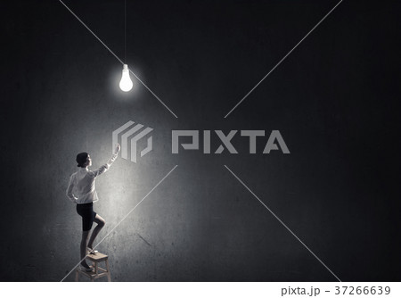 Businesswoman reaching light bulb 37266639