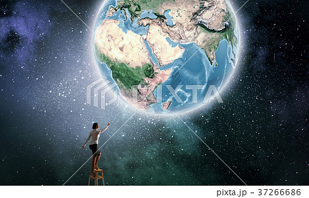 Businesswoman reaching Earth planet Businesswoman reaching Earth planet 37266686