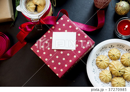 A christmas gift with red wrapping and dessert 37270985