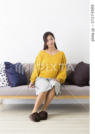 ソファに座るミドル女性の写真素材
