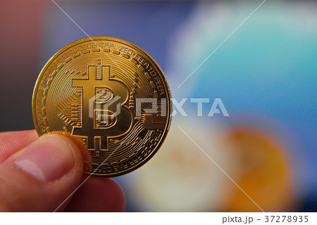 Male hand holding bitcoin, dollar background, 37278935