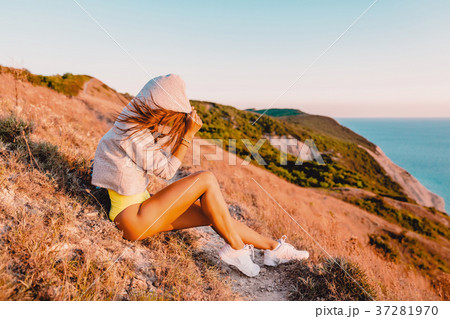 Young woman relaxing in nature at warm sunset Young woman relaxing in nature at warm sunset 37281970