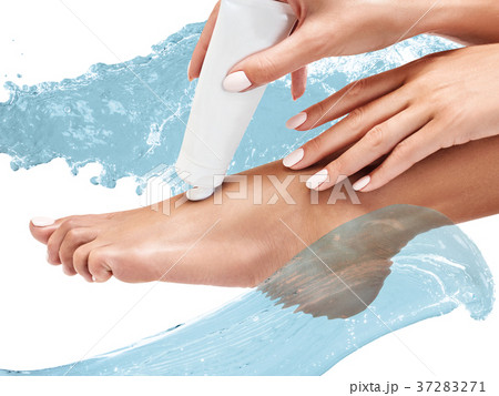 Female feet with cream among water splashes. 37283271