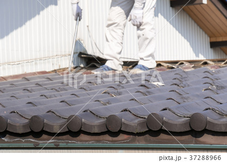 屋根工事 瓦の葺き替え　古い瓦をバールで剥がす 37288966