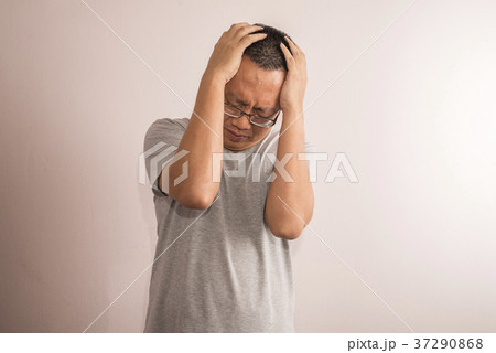 Asian man having a serious headache. 37290868