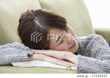 リビングで仮眠する女性の写真素材