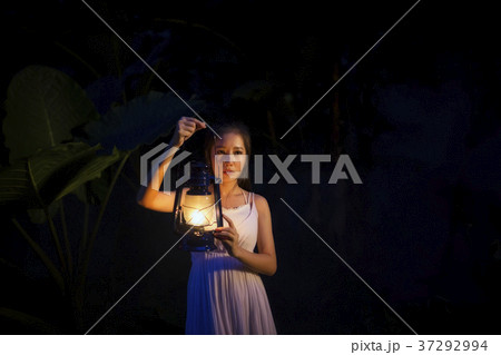 Beautiful woman holding lantern light Beautiful woman holding lantern light 37292994
