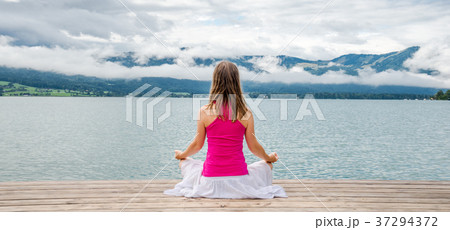 Woman meditating at the lake 37294372