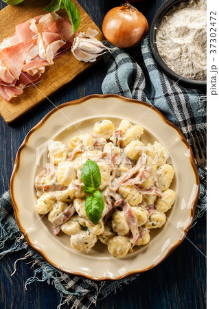 Potato gnocchi, Italian potato dumplings with cheese sauce, ham 37302472