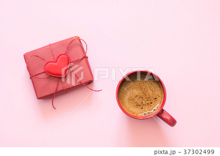 Cup of coffee and gift with love on pastel pink. Cup of coffee and gift with love on pastel pink. 37302499