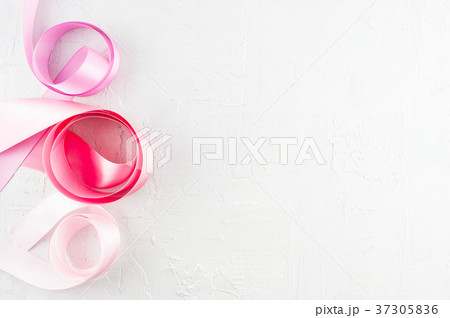 White textured background with pink satin ribbons White textured background with pink satin ribbons 37305836