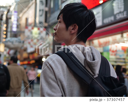 繁華街を歩く男性の後ろ姿の写真素材
