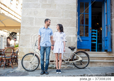 Guy and girl near tandem bike, walls and vintage door 37308100