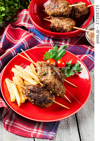 Barbecued kofta with fries on a plate 37308725