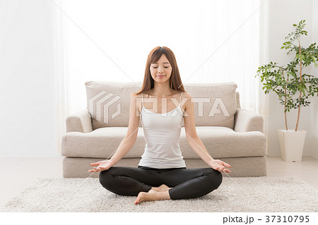 リビングでヨガをする女性の写真素材