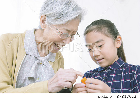 折り紙を折るおばあちゃんと女の子 折り紙を折るおばあちゃんと女の子 37317622
