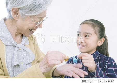 折り紙を折るおばあちゃんと女の子 折り紙を折るおばあちゃんと女の子 37317637