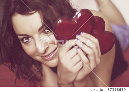 Young woman in love with two red hearts Young woman in love with two red hearts 37318639