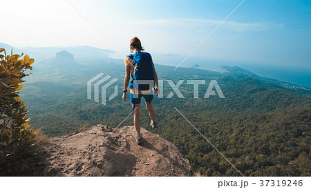 woman hiker walking on cliff edge top of mountain woman hiker walking on cliff edge top of mountain 37319246