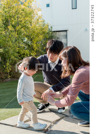 庭先で子供をあやす両親 37322745