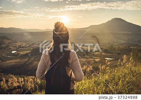 Young woman traveler looking at sunrise Young woman traveler looking at sunrise 37324998