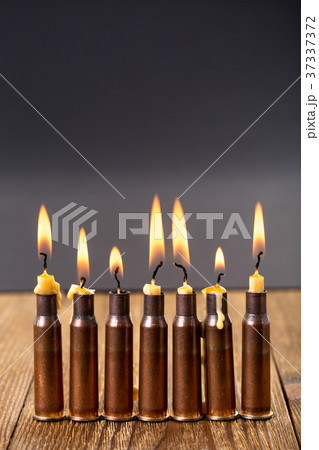 Burning candles and empty rifle cartridges. 37337372