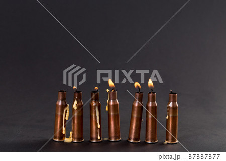 Burning candles and empty rifle cartridges. 37337377