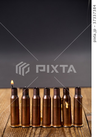Burning candles and empty rifle cartridges. 37337384
