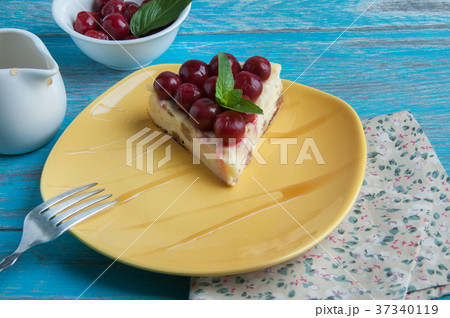 Yellow plate with a piece of cheesecake 37340119