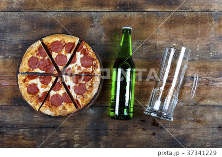 Beer and pepperoni pizza on a wooden table 37341229
