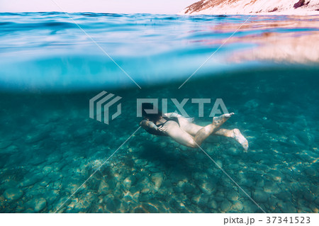 Slim woman dive underwater in blue sea Slim woman dive underwater in blue sea 37341523