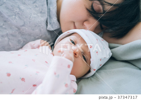 Mom with pleasure sniffing her newborn baby Mom with pleasure sniffing her newborn baby 37347317