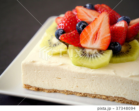 いちごとキウイのレアチーズケーキ 黒背景 横位置 の写真素材