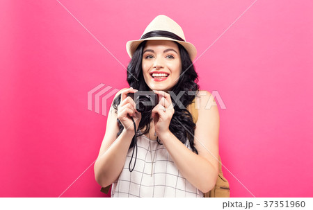 Traveling young woman holding a camera Traveling young woman holding a camera 37351960