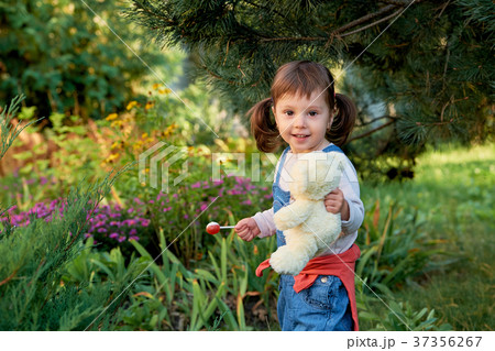 beautiful little girl eats candy. 37356267