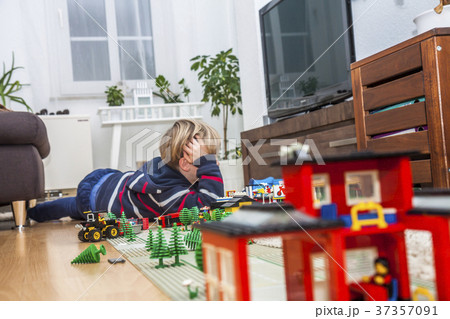 Little boy playing with bricks on the floor 37357091