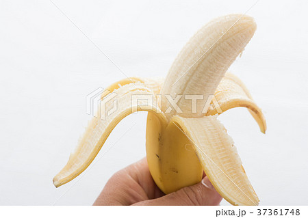 バナナの皮をむく 白背景の写真素材