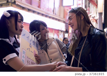 東京ナイト メイドと握手する外国人女性の写真素材