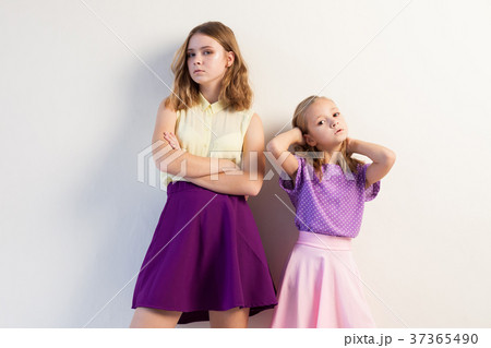 two sisters girls in colored dresses white walls two sisters girls in colored dresses white walls 37365490