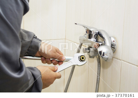 Plumber hands fixing water tap with spanner Plumber hands fixing water tap with spanner 37370161