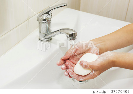 Washing of hands with soap under the crane with 37370405
