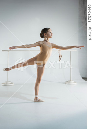The girl is training near the ballet barre. 37370440